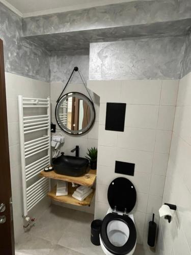a bathroom with a black toilet and a mirror at Norderney Apartments in Sibiu