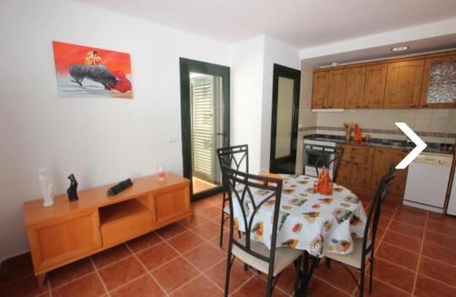 a room with a table and a kitchen with a table and chairs at Villa con piscina, vistas, dunas, mar, 6 personas in Corralejo