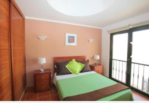 a bedroom with a bed with a green pillow on it at Villa con piscina, vistas, dunas, mar, 6 personas in Corralejo