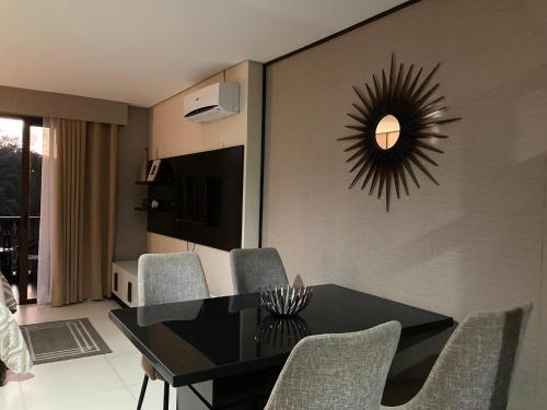 a dining room with a black table and chairs at Crosswinds Nature View Suite in Tagaytay