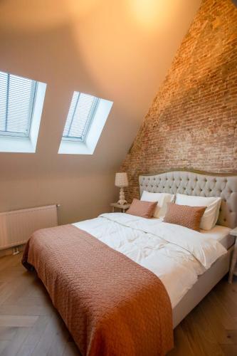 a bedroom with a large bed with a brick wall at Luxe appartementen Havenzicht in Sint Annaland