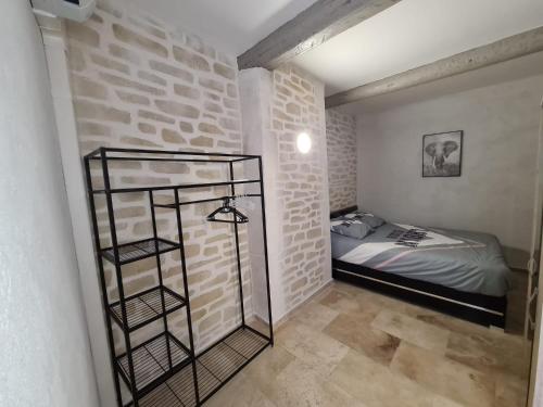 a bedroom with a bed and a brick wall at Maison centre ville avec accueil hôte in Manosque