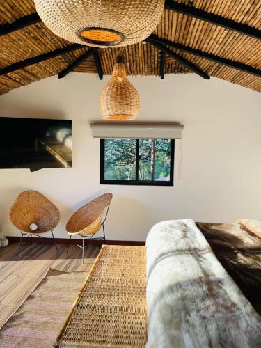a bedroom with two chairs and a bed and a window at leremita biohotel in Silvia