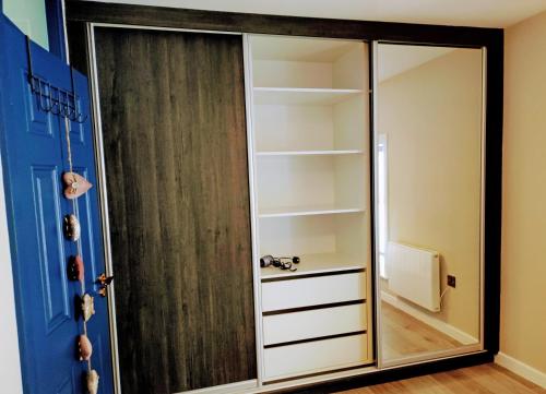 a closet with a mirror next to a door at Tralee Townhouse Holiday Home by Trident Holiday Homes in Tralee