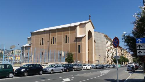 a building with cars parked on the side of a street at savonaamare 2.0 in Savona