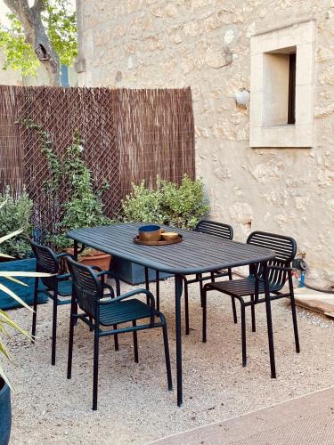 - une table de pique-nique noire et des chaises dans la cour dans l'établissement La Blanchisserie, à Maussane-les-Alpilles