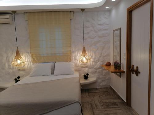 a bedroom with a white bed and two lights at Blue Sky Summer in Naxos Chora