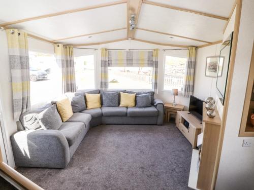 a living room with a couch and a tv at The Maples in Millom