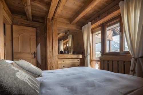 Schlafzimmer mit einem Bett und einem Fenster in der Unterkunft Cortina Lodge Stunning View R&R in Cortina d'Ampezzo