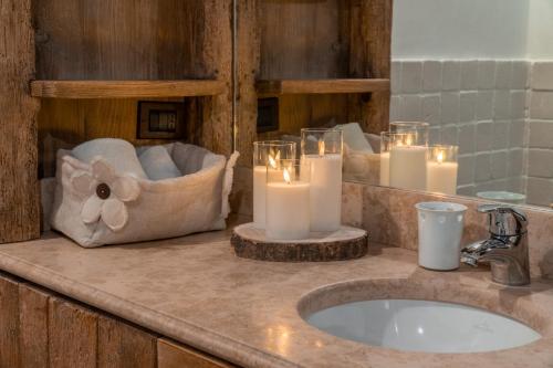 a bathroom with candles on a counter with a sink at Cortina Lodge Stunning View R&R in Cortina dʼAmpezzo