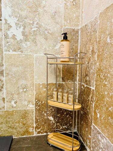 a shelf with a bottle on it in a bathroom at Domaine de Chalvêches Hôtel SPA 4* in Faugères