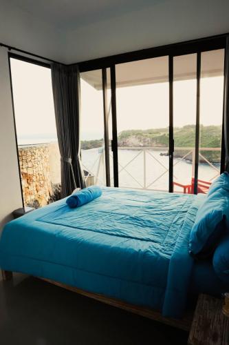 a bedroom with a bed with a view of the water at Baron Lighthouse Cottage & Eatery in Baron