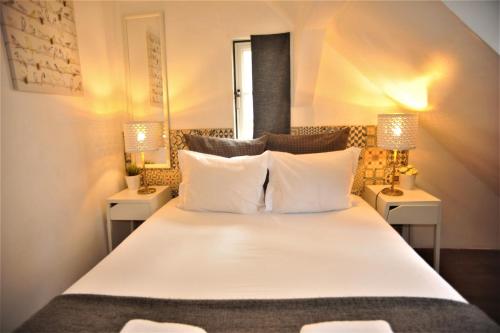 リスボンにあるSantos - Upper Loft with River Viewのベッドルーム(白い大型ベッド、ランプ2つ付)