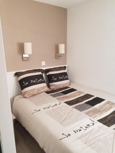 a bedroom with a bed with two pillows on it at Appartement en bord de mer in Cannes