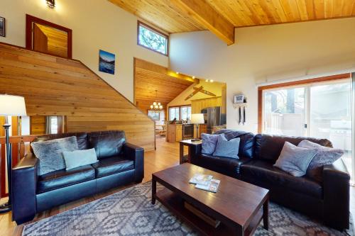 a living room with two leather couches and a table at Infinite Adventure in Sunriver