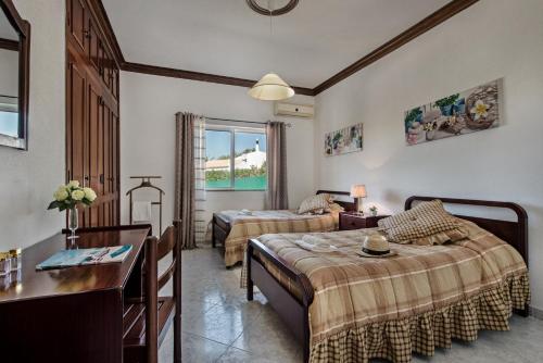 een hotelkamer met twee bedden en een bureau bij Villa Cadre - 5BR w Private Pool & Snooker Table in Armação de Pêra
