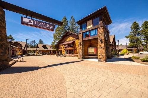 a building with a sign that reads the village at Infinite Adventure in Sunriver