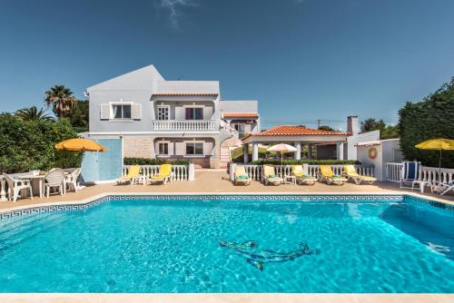a villa with a swimming pool in front of a house at Villa Cadre - 5BR w Private Pool & Snooker Table in Armação de Pêra