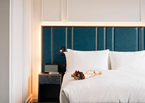 Una cama con sábanas blancas y un ramo de flores. en Page8, Page Hotels, en Londres
