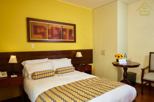 a bedroom with a bed with a yellow wall at Hotel Los Tambos Boutique in Arequipa