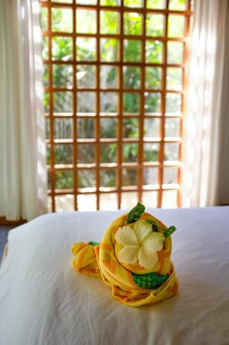 a flower on top of a bed with a window at La Paz del Caribe Adults Only in Puerto Viejo