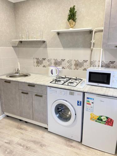a kitchen with a washing machine and a sink at Вип 1комн Айтиева 70 in Uralsk