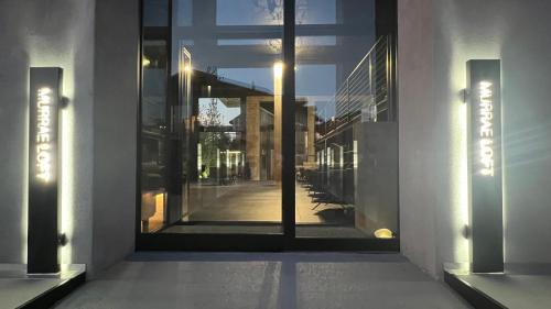 una puerta de cristal de un edificio con un pasillo en Murrae Loft en La Morra
