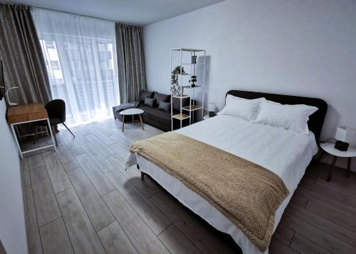 una camera con un grande letto e un divano di KronBed Apartments a Braşov