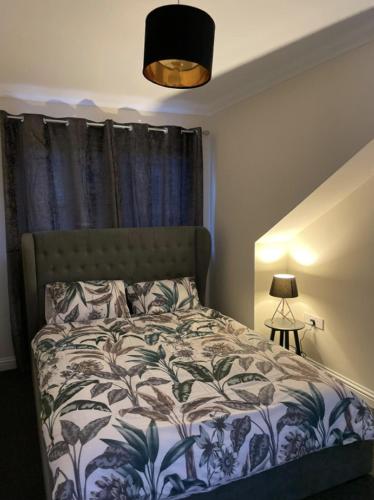 a bedroom with a bed with a blue and white blanket at Ben View Apartments Flat A in Caol