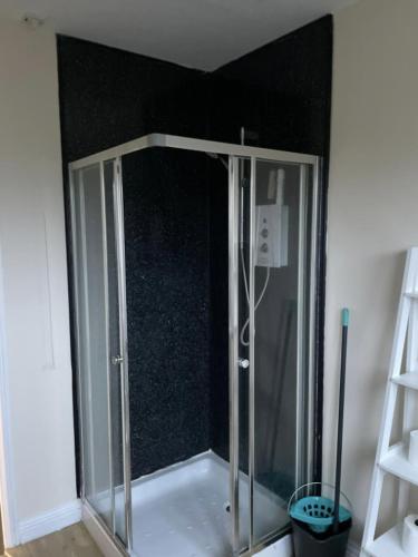 a shower in the corner of a room at Ben View Apartments Flat A in Caol