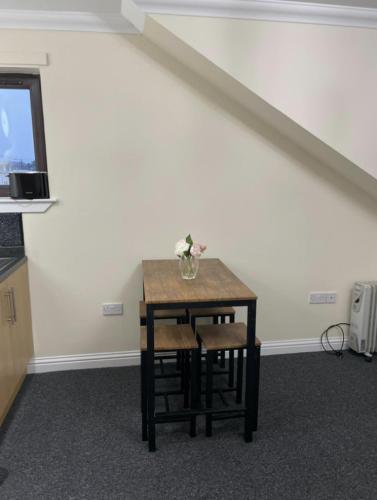 a small table with a vase of flowers on it at Ben View Apartments Flat A in Caol