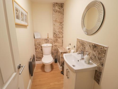 a bathroom with a toilet and a sink and a mirror at The Wheat House in Stratford-upon-Avon