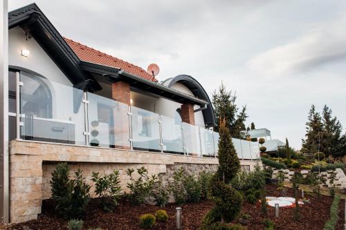 a house with glass windows on the side of it at Bagoly Wellness Apartman 2 in Pécs