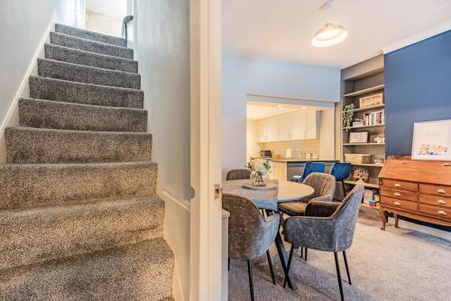 a living room with stairs and a table and chairs at 4 Segontium Terrace in Caernarfon