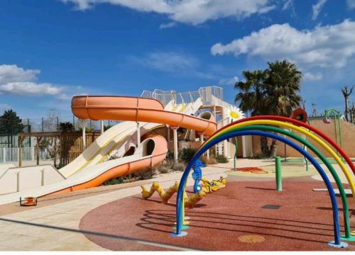 um parque aquático com escorrega e escorrega aquático em Mobile home à louer 8 personnes em Valras-Plage