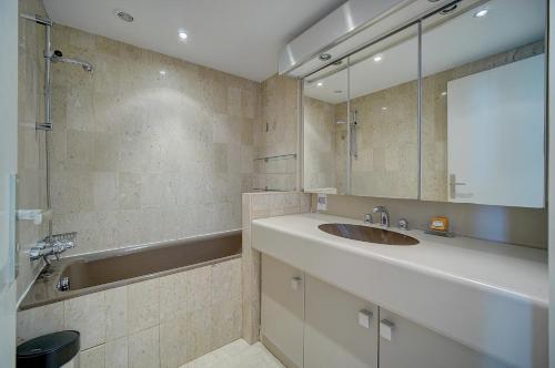 une salle de bain avec un lavabo et une baignoire dans l'établissement GRA3 - Studio cabine, centre ville, à Cannes