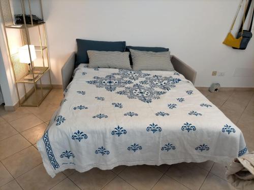 Una cama con una manta azul y blanca. en appartamento incantevole a due passi dal mare a Viserbella vicino fiera Rimini en Rímini