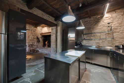une cuisine avec un comptoir et un mur en pierre dans l'établissement il Friscello, à Loro Ciuffenna