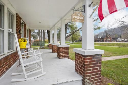 a porch with chairs and a sign on a house at Charming 4 bedroom farmhouse with large backyard for entertaining in Mountain City