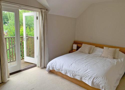 a bedroom with a white bed and a balcony at Churchmount Holiday Home Roundwood by Trident Holiday Homes in Wicklow
