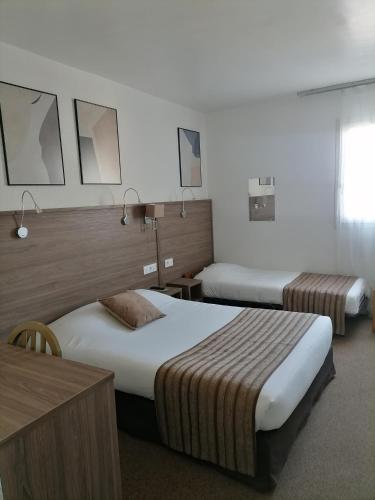 a hotel room with two beds in a room at La Buissonnière in Corbigny