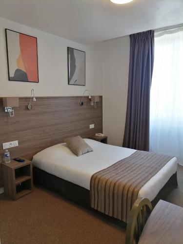 a hotel room with a bed and a window at La Buissonnière in Corbigny