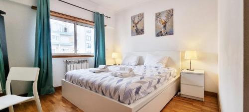 a white bedroom with a bed and a window at Down Town Apartment - EXPO27 in Lisbon