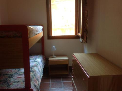 una camera da letto con due letti a castello e una finestra di Casa delle lantane climatizzata a Villaputzu