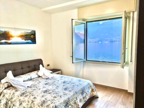 1 dormitorio con cama y ventana grande en Infinity Luxury, en Lezzeno