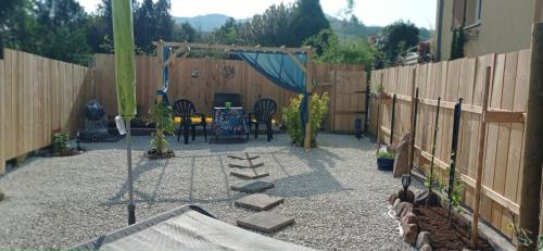 a patio with a fence and a table and chairs at Le p'tit coin de chez nous in Dambach-la-Ville