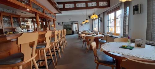 a restaurant with tables and chairs and a bar at Hotel Silbertanne in Hohegeiß