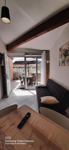 een woonkamer met een bank en een tafel bij Jardins de Neptune - villa en résidence avec piscine in Saint-Cyprien