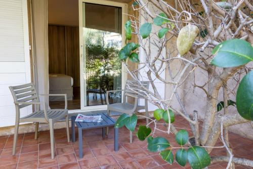 two chairs and a table on a porch at Hôtel Casa Rossa & Spa in LʼÎle-Rousse