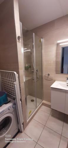 een badkamer met een douche en een wasmachine bij Jardins de Neptune - villa en résidence avec piscine in Saint-Cyprien